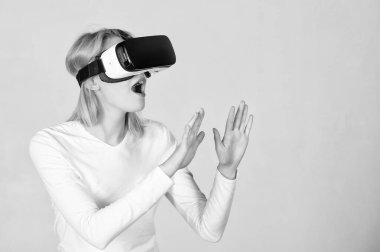 Woman wearing virtual reality goggles. Person with virtual reality helmet isolated on grey background. Woman with virtual reality headset. VR gaming. clipart