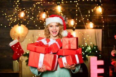 Yılbaşı partisi. Noel Baba şapkası hediye kutusundaki kız. Mutlu noeller. Neşeli kadın Noel hediyesini paylaşıyor. Mutlu yıllar. Noel 'i ailenle kutluyorsun. Kış tatili ve tatil. Noel alışverişi