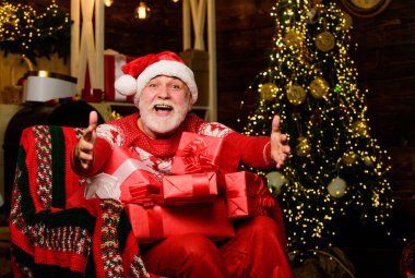 Onu bana ver. Mutlu noeller. Yaşlı büyükbaba evde. Hediye teslimatı. Kış tatili Noel Baba dinleniyor. Gelenekler konsepti. Noel Baba Noel ağacının yanında. Sakallı kıdemli Noel Baba.