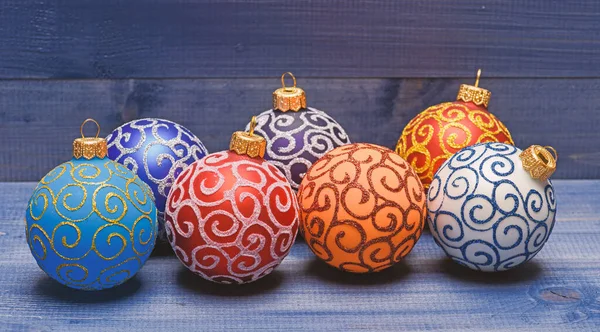 Conceito de decorações de Natal. Escolha decorações coloridas. Decoração moderna de Natal. Bolas com brilho e ornamentos decorativos cintilantes. Decorações de ornamentos de Natal no fundo de madeira vintage — Fotografia de Stock