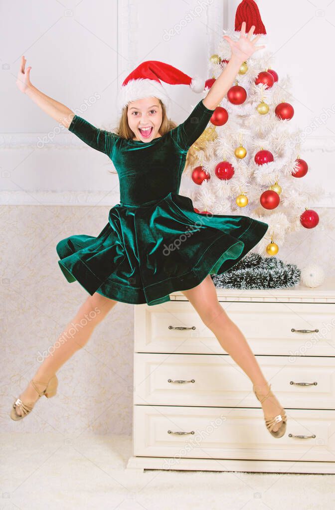 Child emotional cant stop her feelings. Celebrate christmas concept. Girl in dress jumping. It is christmas. Day we have waited for all year finally here. Girl excited about christmas jump mid air