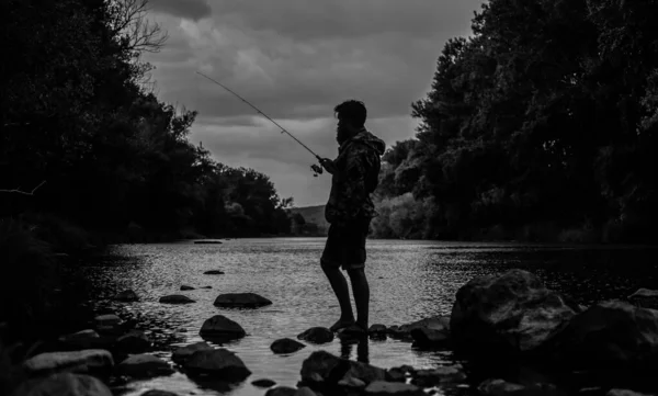 Pescador pacífico. piscicultura piscicultura cría de pescado comercialmente. Estanque de laguna de lago de río. Granja de truchas. Pescador solo de pie en el agua del río. Equipo de pesca del pescador. Hobby actividad deportiva — Foto de Stock