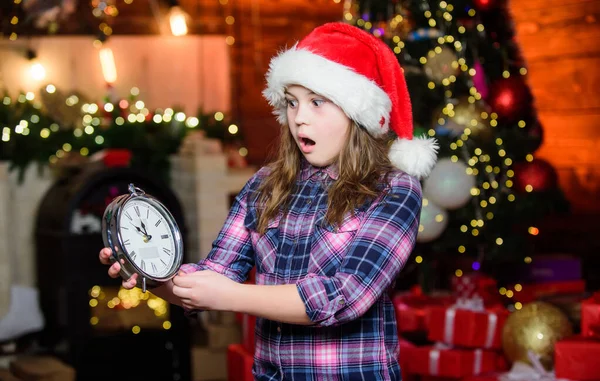 Ambiente festivo el día de Navidad. Cuenta atrás de año nuevo. Contando el tiempo. Faltan pocos minutos para el año nuevo. Llega el momento mágico. Navidad casi aquí. Chica Santa Claus sombrero y reloj. Conoce vacaciones de Navidad —  Fotos de Stock