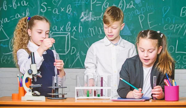 Little kids earning chemistry in school lab. biology experiments with microscope. Little girls and boy in lab. Chemistry science. Little children. Science. Concentrated on exam