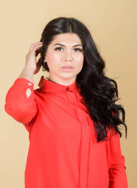 Ateş gibi saçlar. Uzun kıvırcık saçlı kadın. Kumral saçlı güzel bir kadın. Makyaj ve kozmetik. Kadın derisi. moda ve güzellik. Saç dökülmesi ve bakım. Seksi ve şık ol.