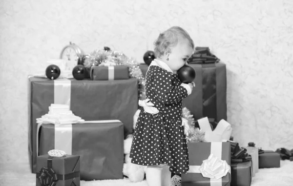 Подарки для первого ребенка. Маленькая девочка играет рядом с кучей подарочных коробок. Семейный праздник. Рождественские мероприятия для малышей. Рождественские подарки для малыша. Что делать с малышами в школе — стоковое фото