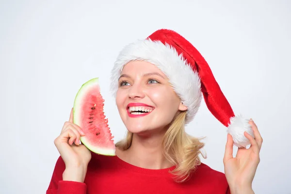 热带圣诞的概念。异国情调的寒假和假期圣诞女孩吃西瓜。女人的桑塔帽子拿着薄片西瓜.异国情调的圣诞庆典圣诞避暑胜地 — 图库照片