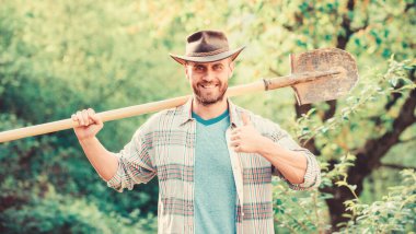 Eko çiftlik. Hasat. seksi çiftçi kürek tutun. tarım ve tarım saldirisi. Bahçe ekipmanları. mutlu dünya günü. Eko yaşam. kovboy şapkalı kaslı çiftlik adamı. Bahçıvan iş başında