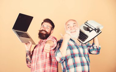 Dijital teknolojiler. Teknoloji savaşı. Eski nesil. Erkekler yazma aletleriyle çalışır. Modern yaşam ve geçmişin kalıntıları. Daktilove hipster dizüstü bilgisayar ile kıdemli adam. Yeni teknolojilere hakim