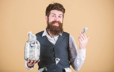 O tamamen zengin. Sakallı zengin bir adam ve yüklü miktarda parası var. Zengin işadamı parayı cam kavanozda saklıyor. Zengin ve para tüccarı