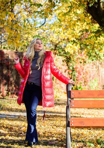 Jacka för höstsäsongens koncept. Kvinnlig fashionabel blondin med makeup stå i höstens park. Flicka bär röd ljus varm jacka. Fall mode koncept. Lady attraktiv fashionista poserar i jacka — Stockfoto