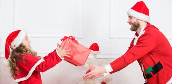 Speelse dochter en vader vieren kerst. Winteractiviteit en plezier. Kind doet alsof hij vecht voor kerstcadeaus. Kerst spelletjes. Maak het leuk. Kid schattig meisje spelen met vader in de buurt van kerstboom — Stockfoto