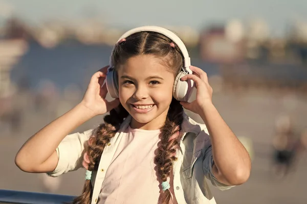 Exciting journeys through cities and museums. Audio tour headphones gadget. City guide and audio tour. Girl little tourist kid explore city using audio guide application. Free style of travelling