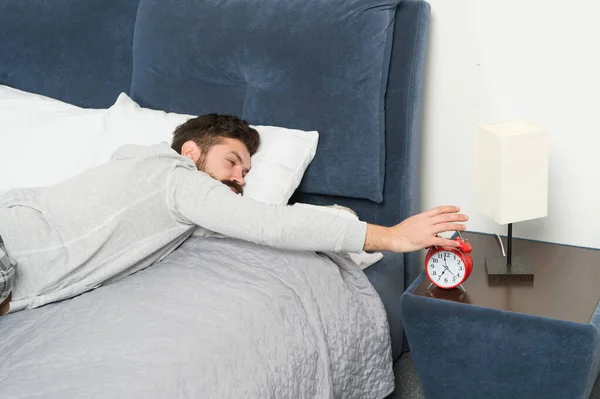 Karma. L'hipster barbuto vuole dormire. risveglio mattutino presto. odio il rumore della sveglia. Fasi del sonno. Un uomo a casa. Concetto sanitario. bisogno di più relax a letto. uomo stressato e infelice — Foto Stock