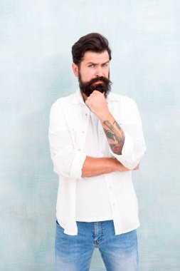 Acımasız maço gri arka plan. Günlük yaşam tarzı. Sakallı adam erkeklik saçıyor. Fiziksel çekicilik. Yakışıklı hippi rahatla. Erkek moda trendleri. Yaz koleksiyonu. Basit ve sıradan.