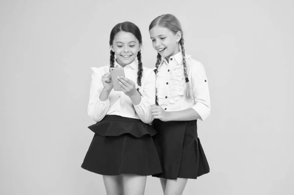 Look here. new technology in education. knowledge day. internet surfing with 4g. kids study online. cheerful pupils with smartphone. little girls in school uniform. back to school. educational blog — Stock Photo, Image