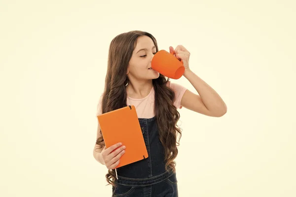 Inspirerend drankje. Meisje schattig kind lang haar drinken cacao of thee. Schoolmeisje met boek of Kladblok en Mok met theepauze. Ontspan en herlaad. Water balans concept. Genieten van thee voor school lessen — Stockfoto