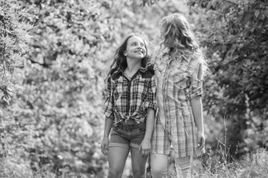 güzel bir yürüyüş. çocuk günü. uzun sağlıklı saçlı mutlu küçük kızlar. saç sağlığı ve bakımı. kuaför moda ve güzellik. uzun kıvırcık saç. kızlar arkadaşlar yeşil ormanda buluşuyor. yaz tatili