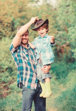 Hafta sonu çiftlikte. Küçük çocuk ve baba doğa arka plan. Macera ruhu. Bahçede küçük bir yardımcı. Çocuk eğleniyor kovboy baba. Çiftlik ailesi. Ebeveyn çiftliğinde tatiller. Büyüyen sevimli kovboy