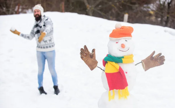 Valódi érzések. téli vakáció szabadtéren. meleg pulóver hideg időben. Boldog hipszter készen áll, hogy megünnepeljük a karácsonyt. téli szezon tevékenység. Karácsony van. Az ember játszik a hóval. szakállas ember építeni hóember — Stock Fotó