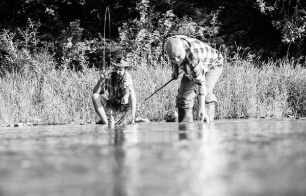 Los hombres se sientan a la orilla del río con equipo de pesca. Cazadores furtivos. Crimen furtivo y licencia de pesca. Caviar del mercado negro. Caza ilegal de caviar. Extrae los huevos del esturión capturado río. Trampa para peces — Foto de Stock