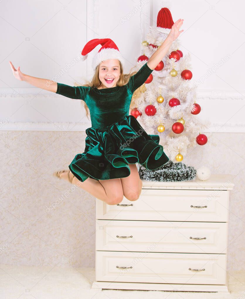 Girl excited about christmas jump mid air. Child emotional cant stop her feelings. Celebrate christmas concept. Girl in dress jumping. It is christmas. Day we have waited for all year finally here