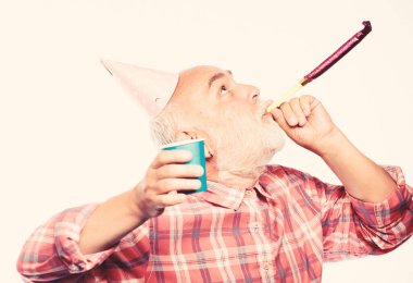 Doğum günü şapkası ve içki fincanı olan adam sakallı büyükbaba. Doğum günü çılgın partisi. Fikirler yaşlılar doğum günü kutlamaları. Büyükbaba graybeard parti düdüğü çalıyor. Yaşlanmak hala eğlenceli. Yaşlılar