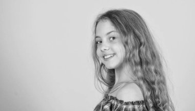 Mutlu çocukluk. Küçük çocuk uzun saçlı neşeli gülen yüz. Küçük kız mutlu gülümsüyor. Mutluluk kavramı. Pozitif ol ve gülümsemeye devam et. Olumlu duygular. Sevimli gülümseme ile sevimli güzellik modeli