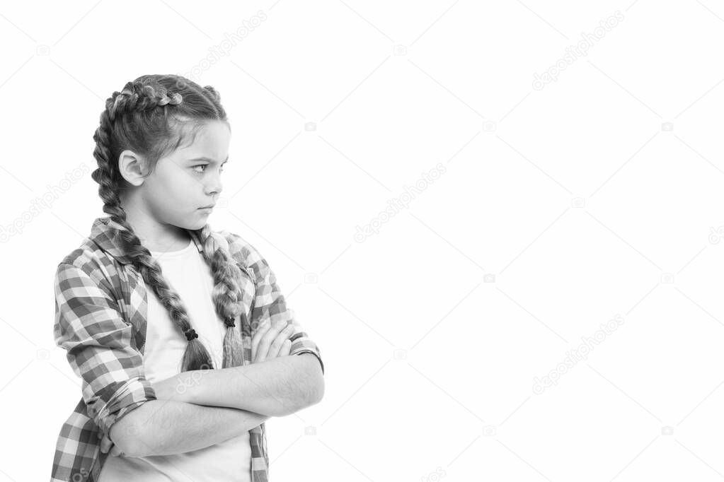 Stubborn child. Disagreement and stubbornness. Girl serious face offended. Kid looks strictly. Girl folded arms on chest looks serious copy space white background. Stubborn temper. Stubborn concept