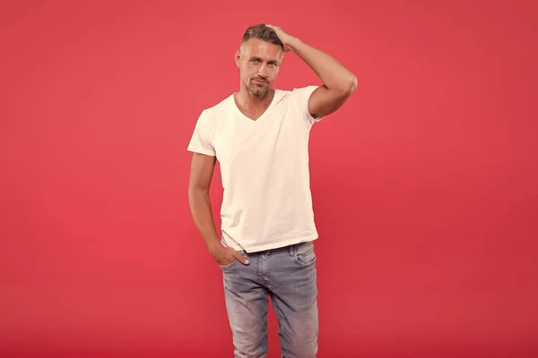 Daily outfit. Man model clothes shop. Menswear and fashionable clothing. Man calm face posing confidently red background. Man looks handsome in casual shirt. Guy with bristle wear casual outfit