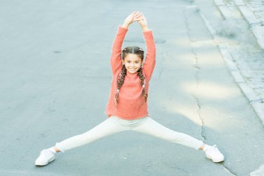 Atletik güzeldir. Atletik çocuklar ayrılır. Küçük kız alt beden atletizm eğitimi yapıyor. Bacak esnetme egzersizi. Isınma egzersizleri. Spor ve spor. Atletik ve esnek