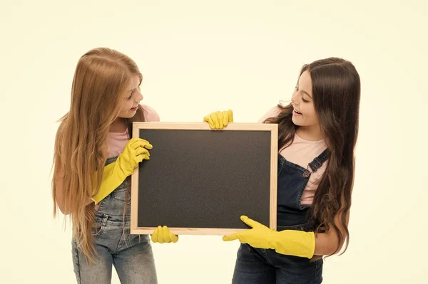 Mantém-no limpo. Crianças de escola em luvas de borracha segurando quadro-negro vazio. Alunos pequenos cumprindo suas funções durante o horário escolar. Estudantes da escola primária mantendo seus materiais escolares arrumados, espaço de cópia — Fotografia de Stock