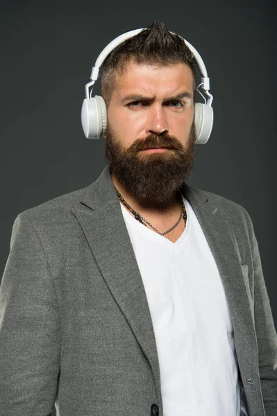 Lifestyle music fan. Man listening music wireless headphones. Hipster use headphones gadget. Inspiring song. Music library. Bearded guy enjoy music. Audio book. Application for listening books
