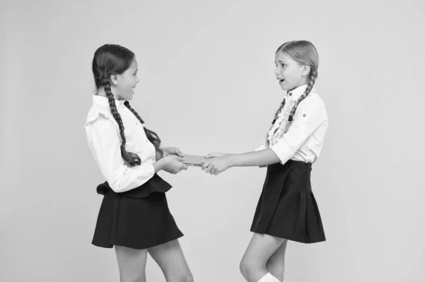 Schoolgirls fight for book. Protect property. Greedy friends. Greedy competitors. Jealous friend. Greedy kids concept. Sisters relations issues. Share book with friend. Classmates rivalry problem — Stock Photo, Image