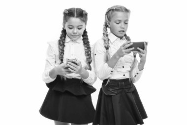 Mobil iletişim inüretimi. Beyaz üzerinde izole mobil cihazlar kullanan küçük öğrenciler. Cep telefonlarında e-ders olan küçük öğrenciler. M-öğrenme veya mobil öğrenme