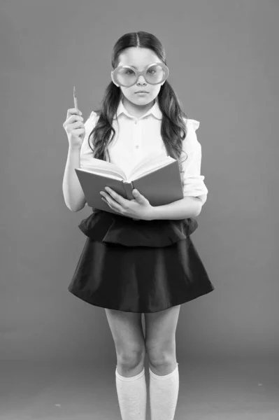 Study literature. Pupil likes study. Small girl enjoying her school time. Happy little schoolgirl ready for lesson. Cute child with book. Only wisdom knowing you know nothing. Study foreign language