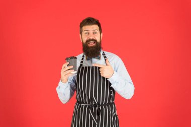 Taze kahve getirdim. Erkek kahve içer. Sakallı adam kahveyi al götür. Kafedeki vahşi garson. Olgun kırmızı arka plan. Yetenekli bir hizmetçi. Barista hipster şef önlüğü. Zarif kendine güvenen barmen