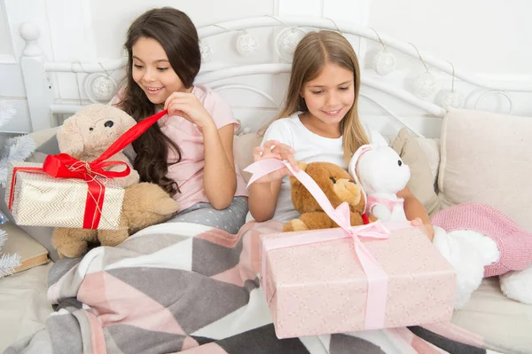 Its time to celebrate. Opening presents on Christmas morning. Happy small children hold gift boxes. Adorable small girls with presents in bed. Merry Christmas and Happy New Year. New Year surprise — Stock Photo, Image
