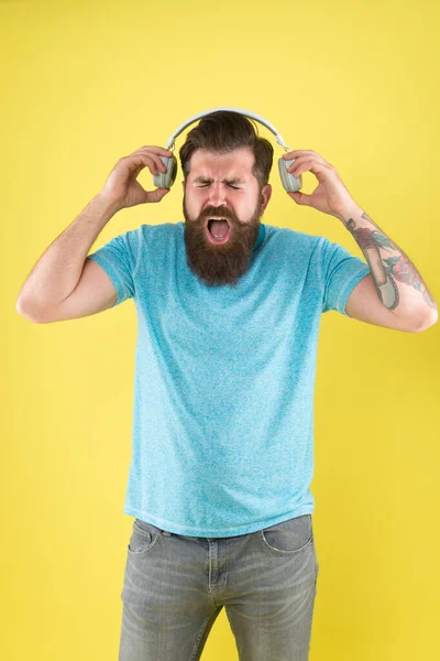 Modern music genre. Bearded man listen and sing to modern song. Modern hipster wear stylish headphones. Using modern technology for pleasure. Fun and entertainment