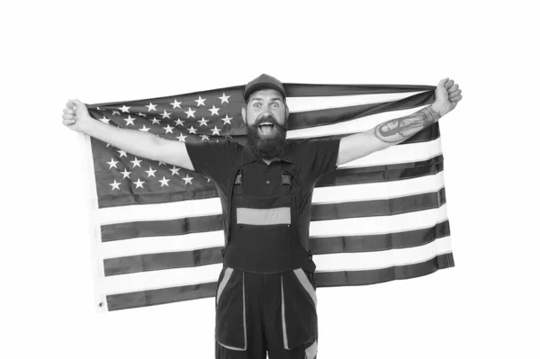 USA flaggan flygs högre än de andra. Skäggiga mannen innehar amerikanska flaggan på självständighetsdagen. Patriotiska arbetare firar flagg dag. Happy hipster i arbetskläder med Förenta staternas nationella flagga — Stockfoto