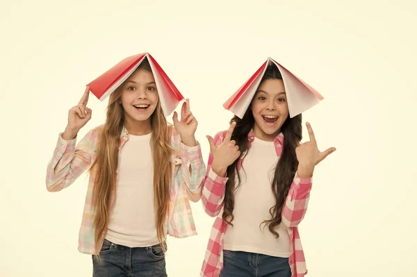 El conocimiento es poder. Adorables colegialas sosteniendo libros sobre cabezas llenas de conocimiento. 1 de septiembre o Día del Conocimiento. El conocimiento se asimila mejor de esta manera —  Fotos de Stock