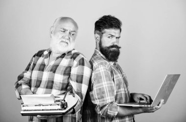 İki sakallı adam. Vintage daktilo. Baba ve oğul. teknoloji geliştirme ve iyileştirme. retro daktilo vs dizüstü bilgisayar. teknoloji üretimi savaş. Modern hayat. gençlik vs yaşlılık. iş yaklaşımı