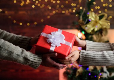 Yeni yıl yaklaşıyor. Noel tatili için hediye. Sevgiyle hediye. Erkek kadına kutu verir. Aile değerleri. Birbirimizi seviyoruz. Birbirine aşık çiftlerin elleri. Mutlu noeller. Mutlu yıllar. kış tatili