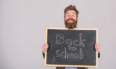 Öğretmen veya sakallı eğitimci kısaltmasıdır ve blackboard başa okul gri arka plan yazıt ile tutar. Okul ve öğretmen seni bekleyeceğim. Öğretmen geri eğitim için bildirir, öğretim yılı başlar