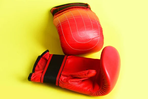 Manoplas para boxeo en color rojo aisladas sobre fondo amarillo —  Fotos de Stock