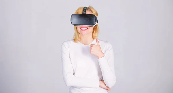Retrato de mulher em uma blusa branca com óculos de realidade virtual na cabeça isolada em fundo cinza. Pessoa com capacete de realidade virtual isolado em fundo cinza. Mulher em RV . — Fotografia de Stock