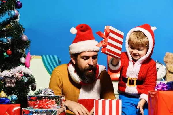 Christmas family opens presents on blue background — Stock Photo, Image