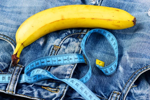 Fruta kinky com fita métrica azul em jeans, close-up — Fotografia de Stock