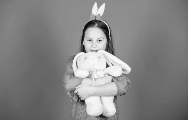 Kutsal Paskalya var. Mavi arka planda sevimli oyuncak ile Bunny kız. Çocuk gülümseyen oyun tavşan oyuncak. Mutlu çocukluk. Paskalya ruhuna gir. Tavşan kulakları aksesuarı. Güzel oynak Bunny çocuk hugs yumuşak oyuncak — Stok fotoğraf