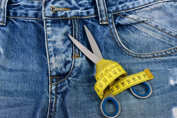 Поршневые инструменты на джинсовой ткани: ножницы и желтая лента — стоковое фото